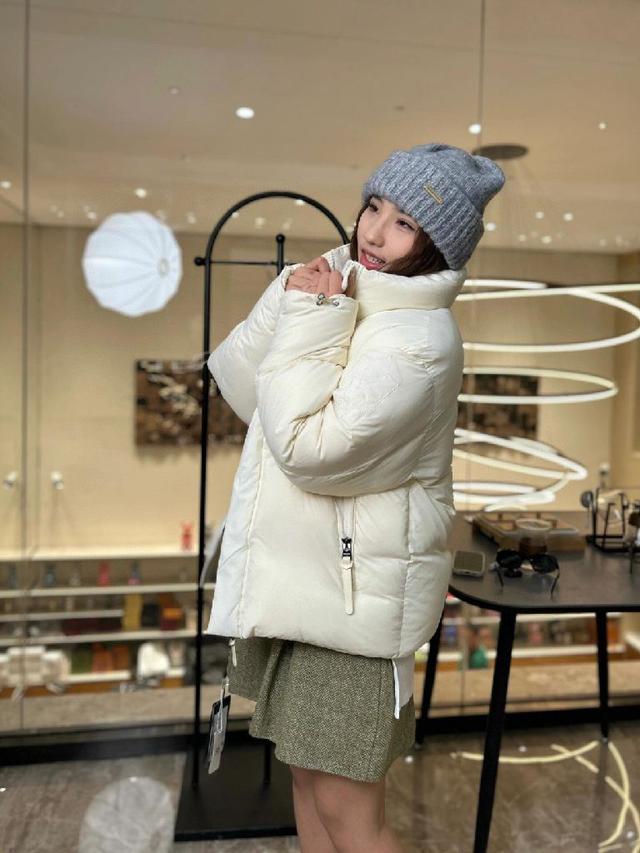 长款羽绒夹克采用聚酯纤维面料制成，具有修长宽摆廓形，收腰设计衬里质感轻盈