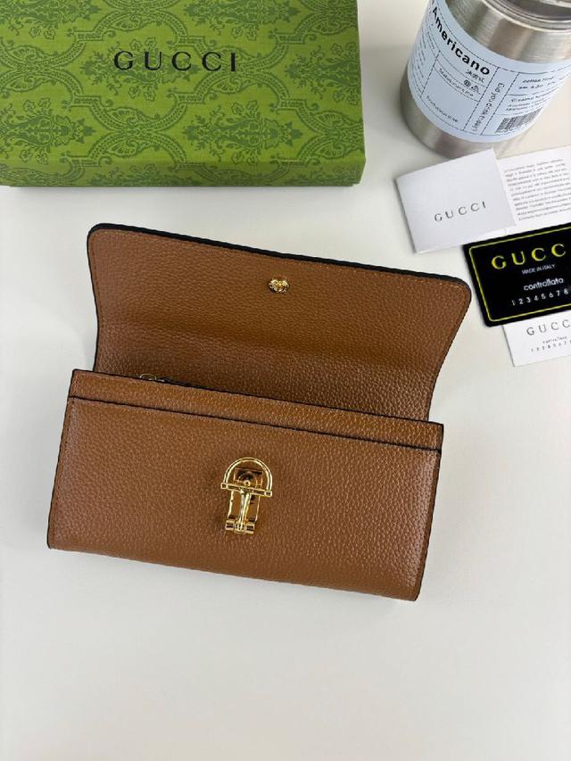 半马衔扣图案化身为开合细节，为多款小皮件增色添彩。这款长夹以绿色